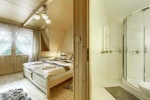 维托韦Góralska rezydencja的一间卧室配有一张床和淋浴,还有一间浴室