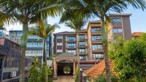 坎帕拉Munyonyo Heights Apartments的一座棕榈树建筑