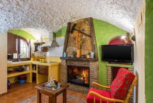 HinojaresCazorla Casas Cueva的客厅设有壁炉和电视。