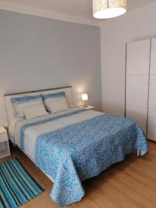 贝雅Beja Garden的一间卧室配有一张带蓝色毯子的大床
