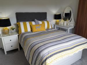 沃克索普Clumber Lane End Farm的一间卧室配有一张带黄色枕头和灯具的床。