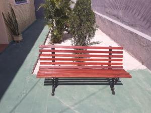 福塔莱萨Hostel Parquelândia的坐在大楼旁人行道上的红色长凳