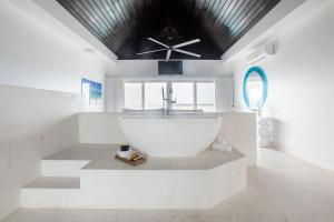普罗维登西亚莱斯岛SulMare at Taylor Bay Luxury villas的一间带大型白色浴缸和吊扇的浴室