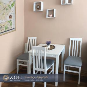 弗尔沙茨ZOE apartment的白色的餐桌,配有两把椅子和白色的桌子