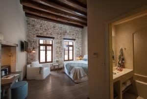 干尼亚瑟乐尼斯玛精品酒店的一间卧室设有一张床和石墙