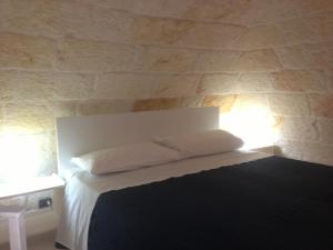 滨海波利尼亚诺坎特努纳住宿加早餐旅馆的一间卧室配有一张带两个枕头的床