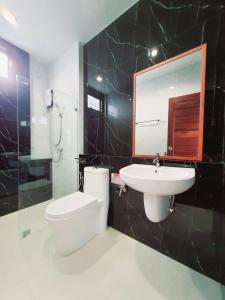 素叻SUhotel Suratthani的一间带卫生间、水槽和镜子的浴室