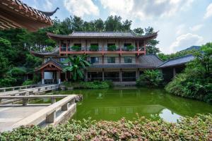 桂林Guilin Yi Characteristic Hotel CoLTD的前面有池塘的建筑