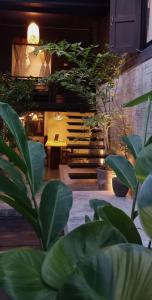 清迈Inn Oon Villa的一间种植了大量绿色植物并配有桌子的房间