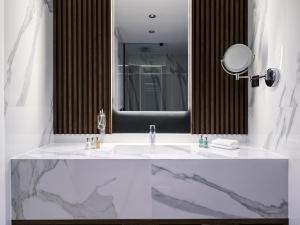 塞萨洛尼基Vanoro Hotel的浴室设有白色水槽和镜子