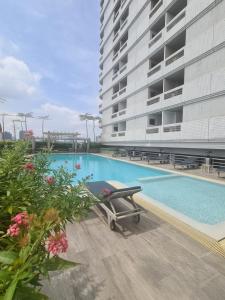 曼谷BU Place Hotel的一座高楼旁边的游泳池