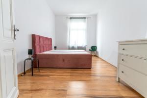 莱格尼察Avalon apart 2的一间卧室设有一张床和一个窗户,铺有木地板