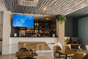 加格拉Aquamarine Family Club的酒吧设有桌子,墙上配有电视