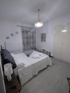阿西西Le Casette di Franco & Anna的白色卧室配有一张床和一个吊灯