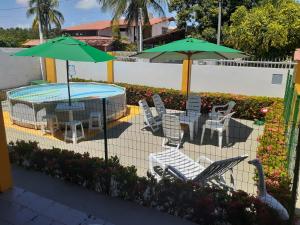 马塞约Casa de Praia Veraneio的一个带桌椅和遮阳伞的庭院