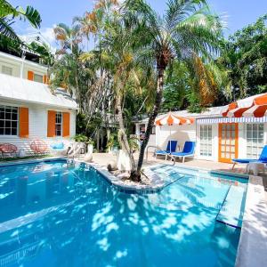 基韦斯特Marreros Guest Mansion - Adult Only的一座房子前面的游泳池,上面有棕榈树