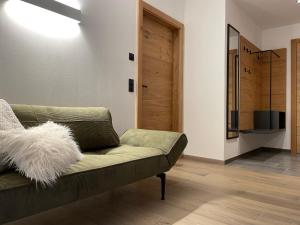 恩斯塔尔豪斯HAUSZEIT APPARTEMENTS的客厅设有绿色沙发和木门。