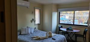 科伊艾科La Ruta de Aysén的一间卧室配有一张床、一张桌子和一个窗户。
