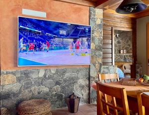 圣卢西亚casa rural LA LIMERA con piscina privada的墙上的电视,上面有篮球比赛
