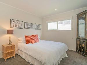 怀蒂昂格Hosts on the Coast Puriri Pride的白色的卧室设有床和窗户