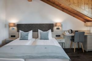 基姆湖畔普林贾尼莫维希酒店的一间卧室配有一张大床和一张带椅子的桌子