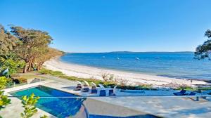 尼尔森湾阿玛纳豪华海滩度假酒店 的一个带椅子的游泳池和海滩
