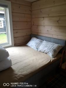 Lenangsøyra莱京滑雪费斯坎普山林小屋的小木屋内的一张床位,设有窗户
