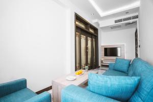 巴格达Noor Land Hotel的客厅配有2张蓝色沙发和1台电视