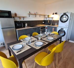 马孔Appartement Mâcon Centre T4 - 100m2的餐桌、黄色椅子和厨房