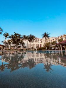 班吉Bangi Resort Hotel的棕榈树度假村前的游泳池