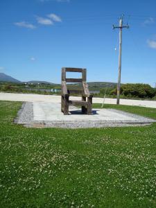 Achill Sound海兰布莱萨尔住宿加早餐旅馆的坐在草地上的木凳