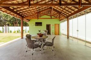 阿拉拉夸拉Espaço Barão - Área de Lazer的一个带桌椅和绿色墙壁的庭院