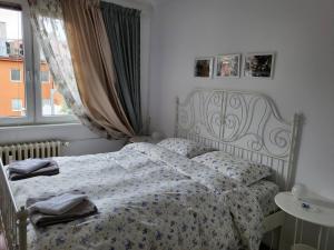 索非亚CasaBella Apartment的一间卧室配有一张带花卉图案的毯子和窗户的床。