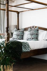 开普敦Royal Boutique Hotel的一间卧室配有带枕头的木床