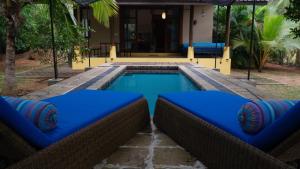 丹不拉Mind Body and Soul的一座房子前面带蓝色靠垫的游泳池