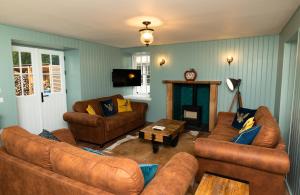 TurriffNetherdale House & The Coach House的客厅设有棕色沙发和壁炉