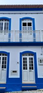 TopoMoradia Machado的蓝色的建筑,设有两扇门和阳台