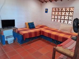 雅克南Casa da Lua的一间设有两张床和电视的房间