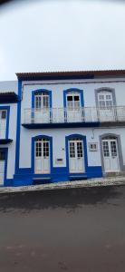 TopoMoradia Machado的蓝色的建筑,设有白色的门和阳台