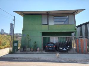 新利马Pousada Vila da Serra - Quarto Cantinho do Sossego的一只狗站在绿色建筑前