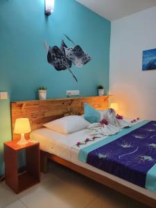 芭环礁Faima Fishing Lodge at Daravandhoo的一间卧室配有一张蓝色墙壁的床