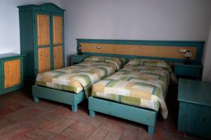 卢戈La Locanda dei Gagliardi的一间卧室配有两张单人床和两张梳妆台。