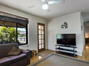 伊鲁卡Tarraloo Iluka NSW的带沙发和平面电视的客厅