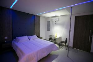 塞蒂拉瓜斯Hauss Excellence Motel的卧室配有一张白色的大床和一张桌子