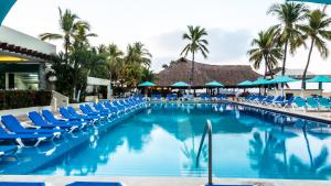 伊斯塔帕丰唐伊斯塔帕酒店的一个带蓝色椅子的游泳池,棕榈树
