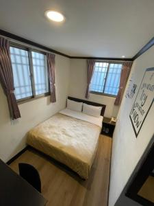 台东假期商务旅馆的一间小卧室,配有床和窗户