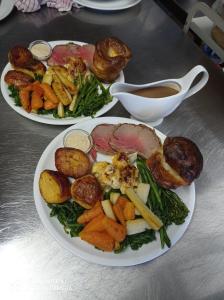 海斯Castle Inn的两盘食物,有肉和蔬菜放在桌上