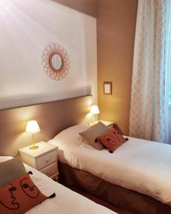 莱蓬德塞果树林餐厅酒店的酒店客房,设有两张床和镜子