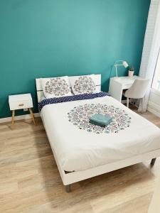 普瓦捷T2 Moderne au Cœur Poitiers的卧室内的一张床铺,卧室内有蓝色的墙壁