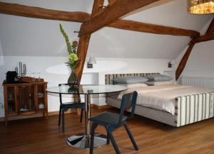 贝克De Oude Limonadefabriek的卧室配有一张床和一张桌子及椅子